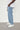 Model wearing Wolfe Denim Light Blue Baggy Jeans – relaxed fit, vintage wash, heavyweight denim, styled with white sneakers and an oversized tee.