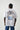 Model wearing Wolfe Denim oversized T-shirt with embroidered logo on front and artistic patchwork back design featuring floral details and statement text.