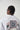 Model wearing Wolfe Denim oversized T-shirt with embroidered logo on front and artistic patchwork back design featuring floral details and statement text.